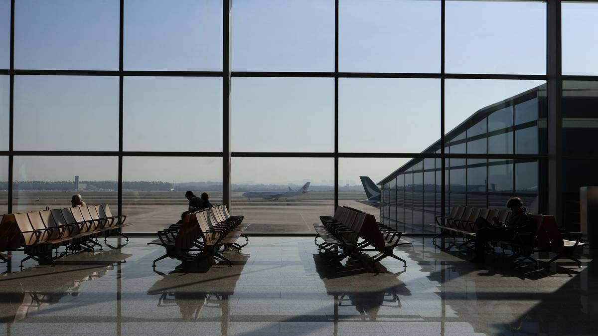 Traveler using redeparture connection insurance to rebook instantly at airport kiosk